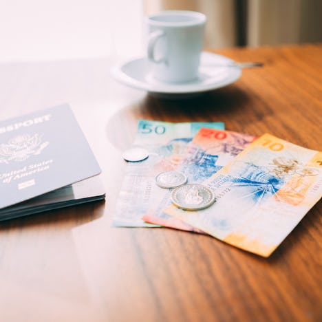 Candid shot of Swiss currency Francs on a hotel room table with authentic looking natural window lig...
