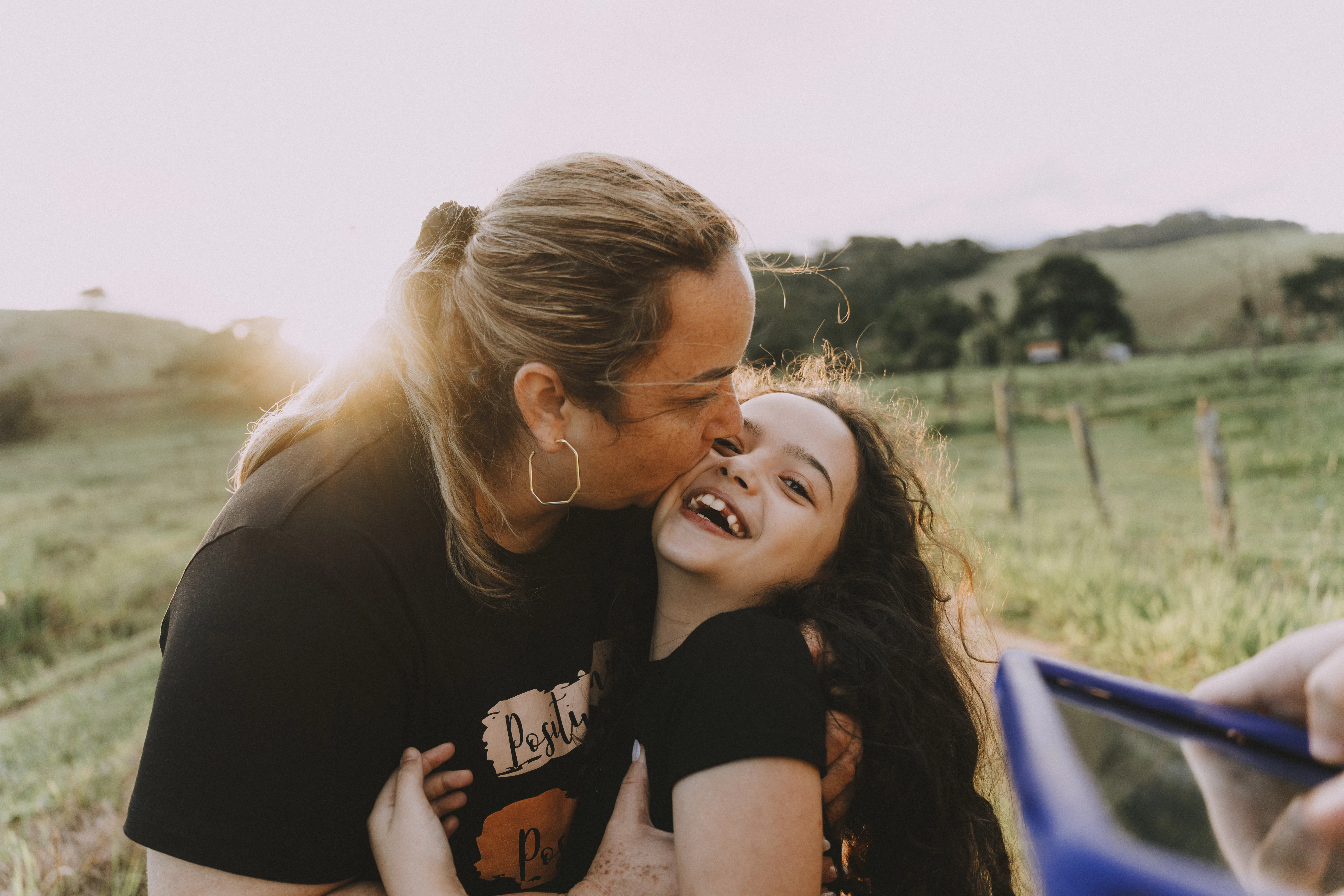 Mother hugging daughter on farm