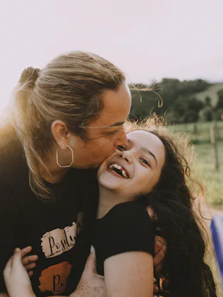 Mother hugging daughter on farm