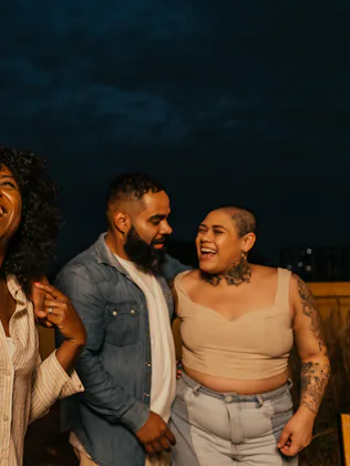 Friends enjoying happy hour, listening to friend playing guitar