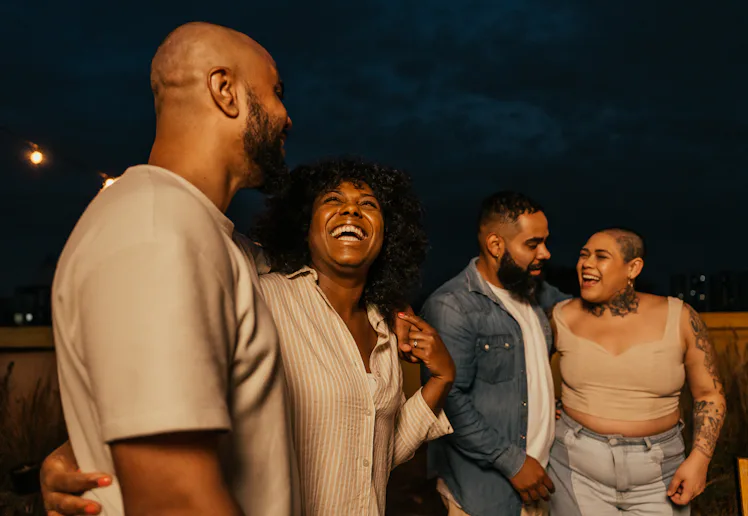 Friends enjoying happy hour, listening to friend playing guitar