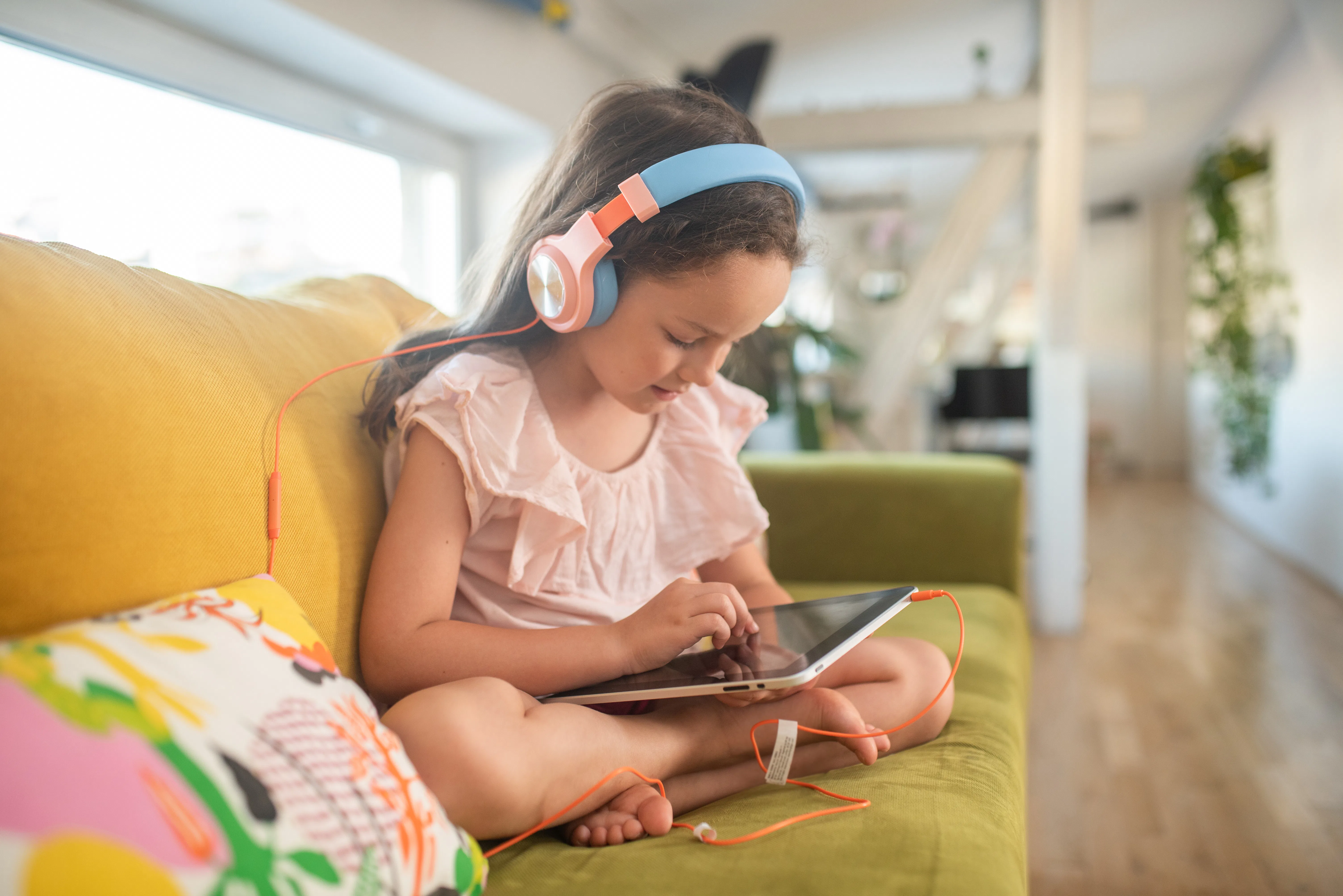 Little girl playing video games on tablet