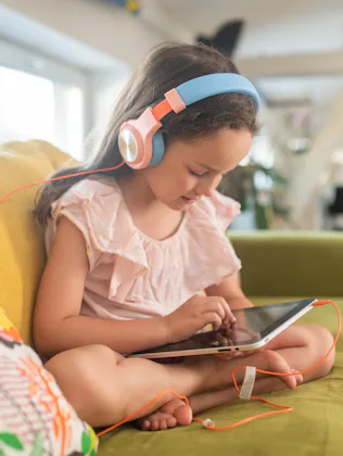 Little girl playing video games on tablet