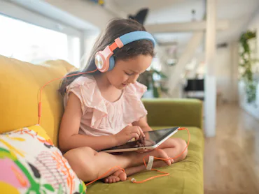 Little girl playing video games on tablet