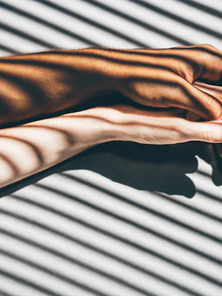 Interracial couple holding hands on the bed.