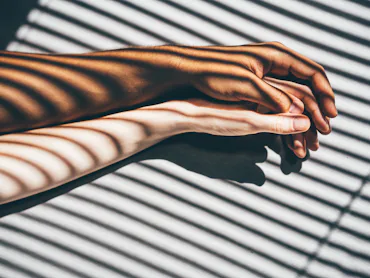 Interracial couple holding hands on the bed.