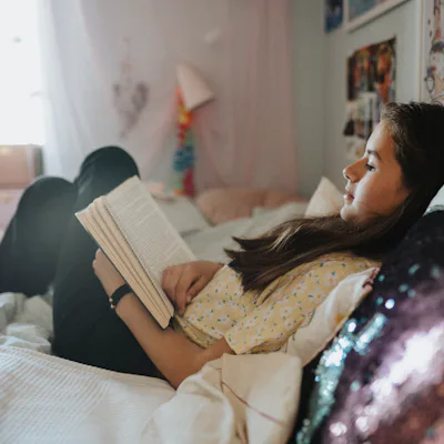 Girl relaxing in bedroom and reading book