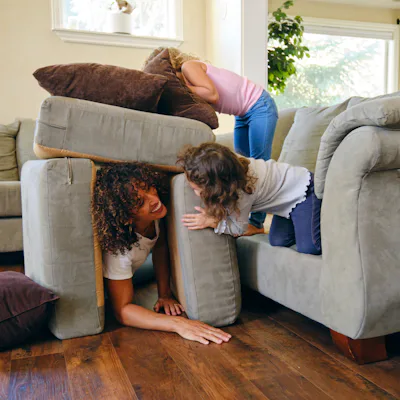 Two little girls, playing in the living room of a home on a play date.