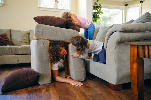 Two little girls, playing in the living room of a home on a play date.