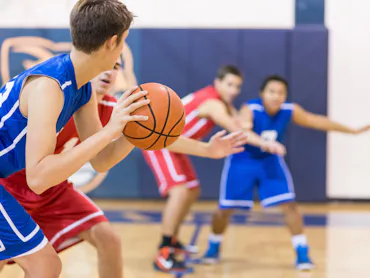 Boys high school basketball team: player about to shoot over defender