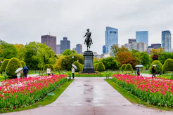 Boston, Massachusetts, USA - May 10, 2025: Tourists with umbrellas on a rainy day in the Boston Publ...