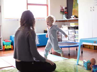 a Toddler and his mother playing in the playroom at home.