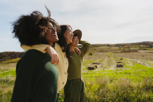 Photo of a group of female friends having a walk on a sunny autumn day in nature
