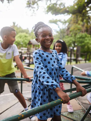 The AAP released new guidelines on recess. Photo shows a little girl playing on a playground with cl...