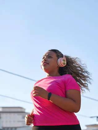 Side view of latin woman with large build running in city
