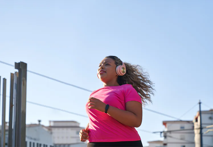 Side view of latin woman with large build running in city