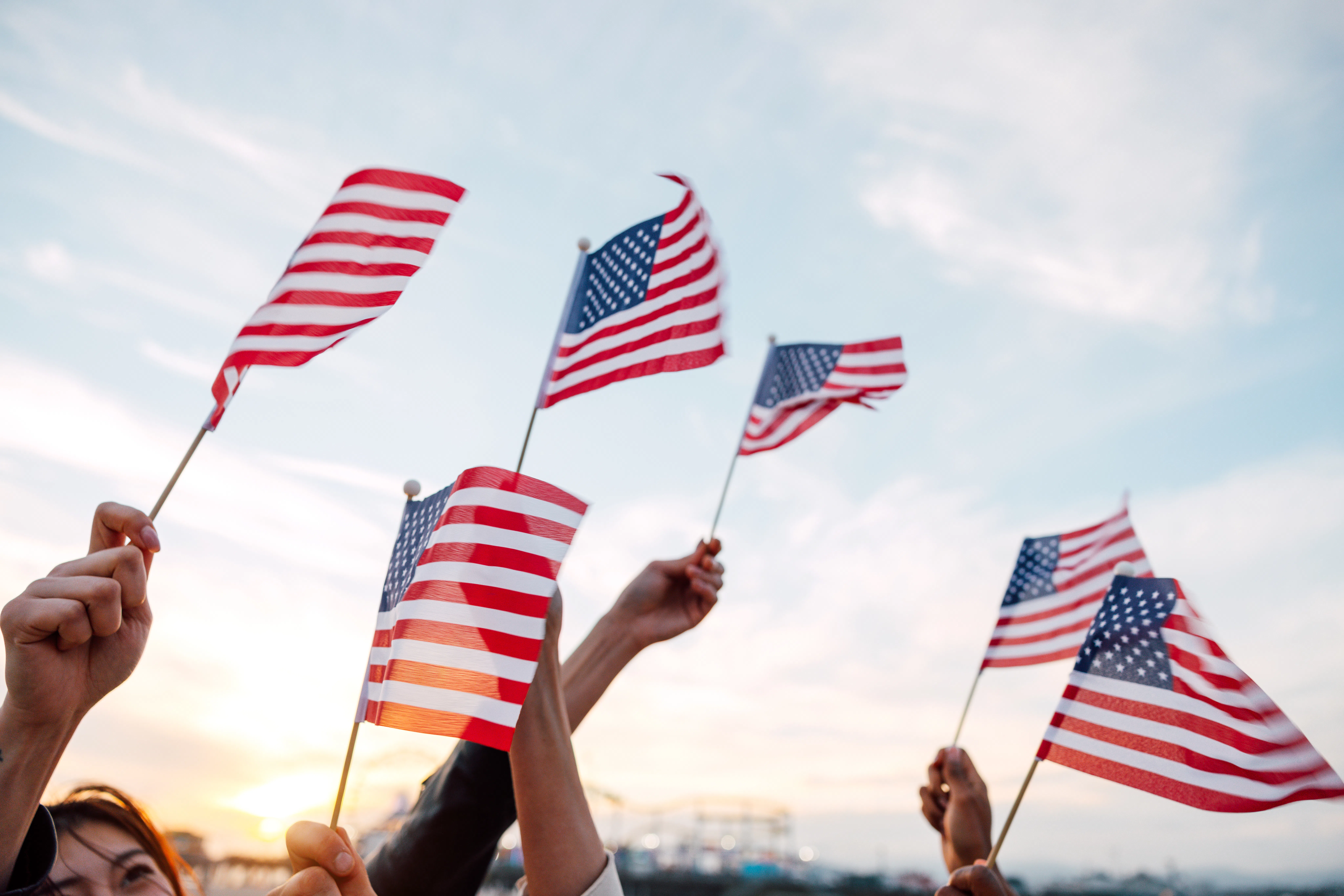 A group of people holding small flags of the USA in their hands