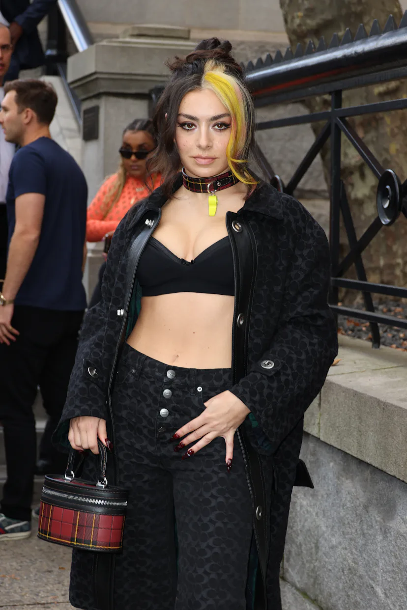 Charli XCX with blonde money pieces in her hair at a fashion show