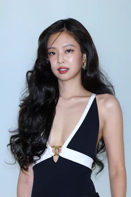 Jennie at the Chanel show in Seoul, standing against a wall