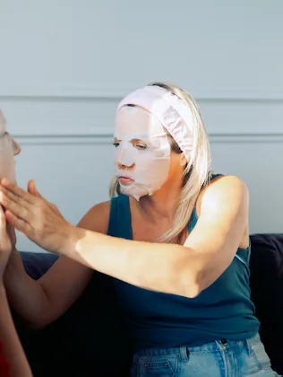 Women friends uses a cosmetic sheet face mask at home