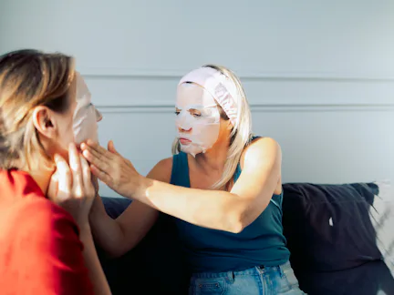 Women friends uses a cosmetic sheet face mask at home