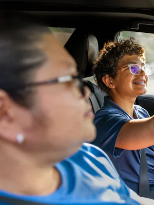 A Fillipino American teaching her multiracial son how to drive.