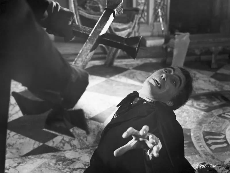 (Original Caption) 1958- Dracula, the human vampire, is shown cringing before the crucifix, is force...