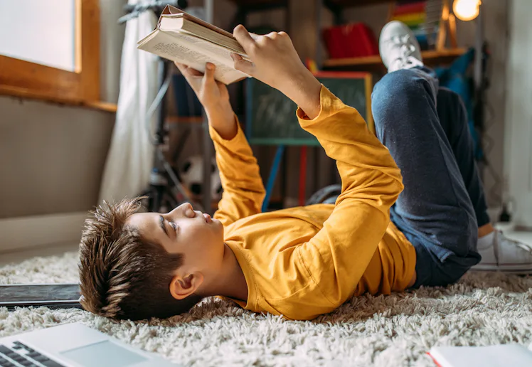 Photo of teenage boy doing homework at home