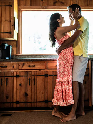 Husband and wife embracing on couch at home
