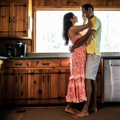 Husband and wife embracing on couch at home