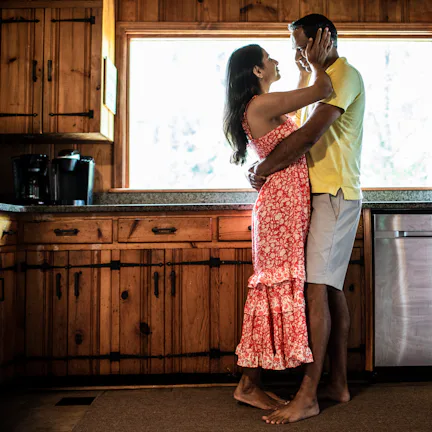 Husband and wife embracing on couch at home