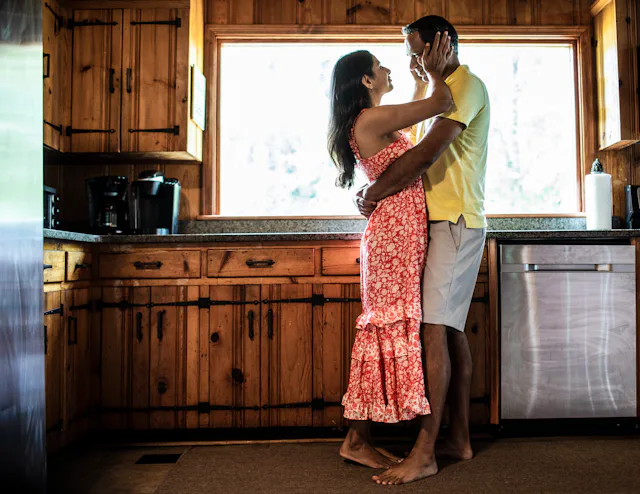 Husband and wife embracing on couch at home