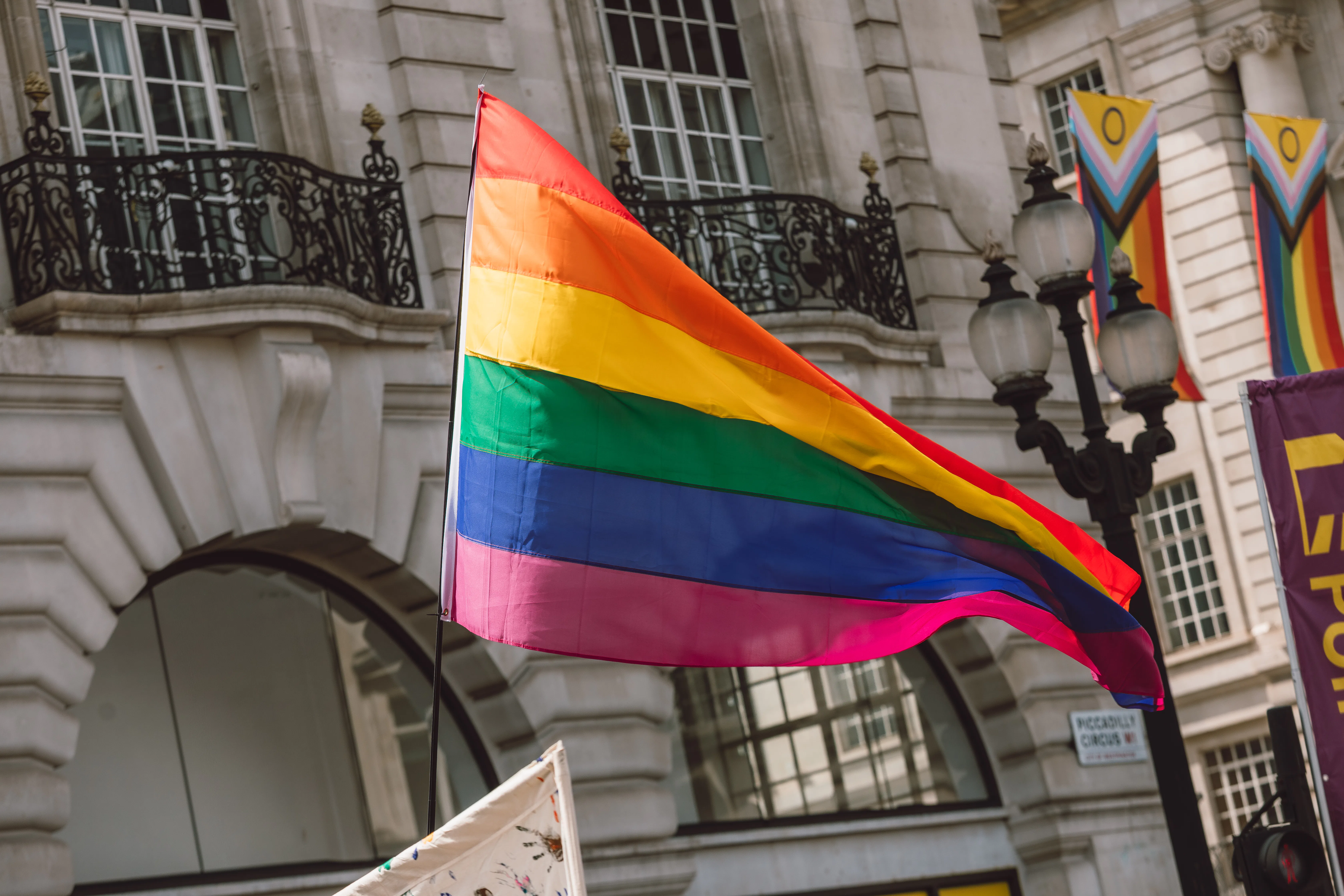 Rainbow pride flag waving in the air during an LGBT public event in Piccadilly Circus, London, Engla...