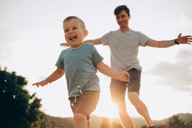 happy family.dad and son play catch-up .sunset light