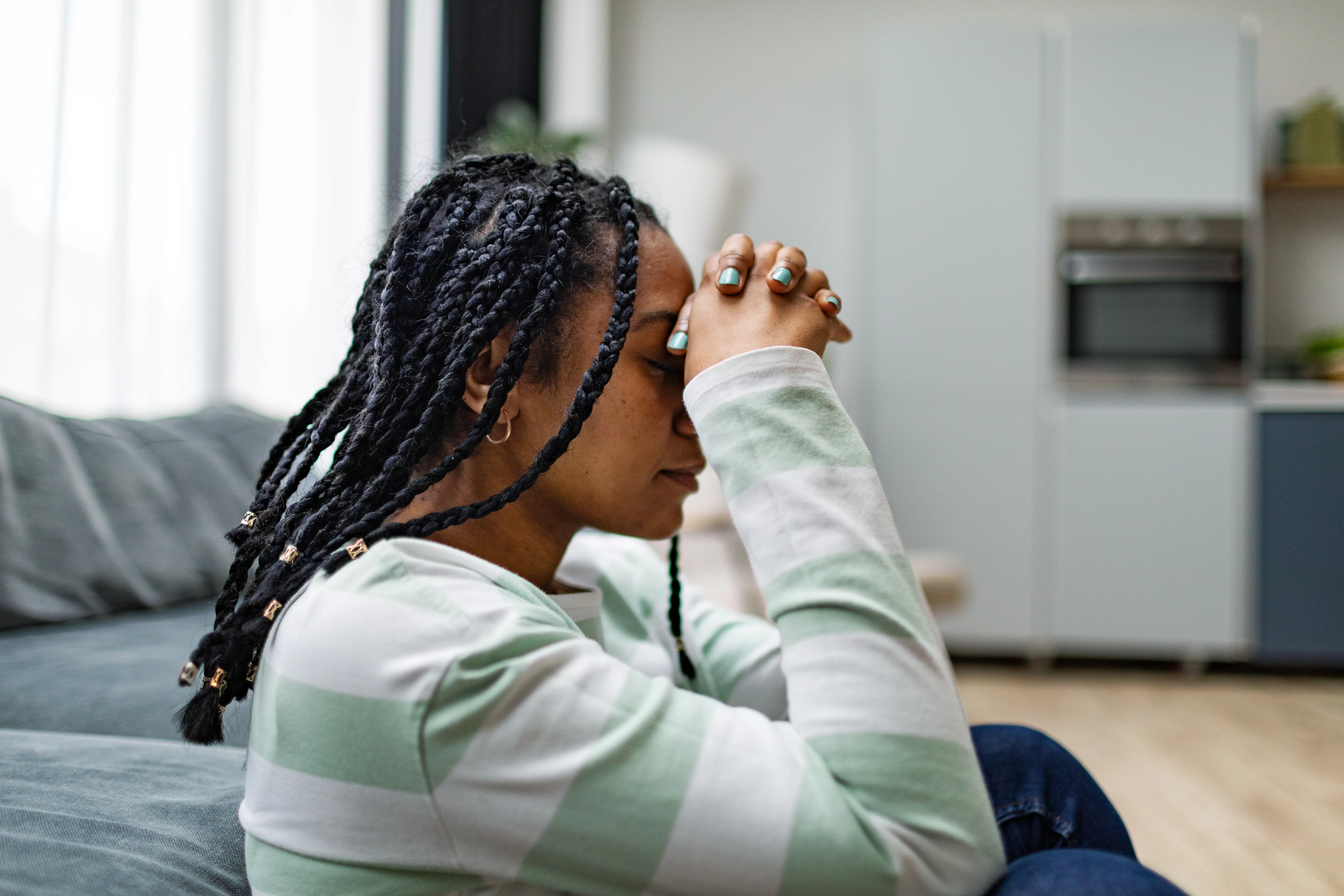 Young black adult woman in depression at home