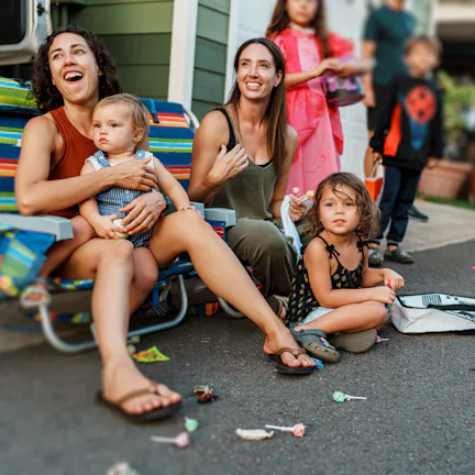 A multiracial group of kids and adults gather along the road in front of their homes in Hawaii as a ...