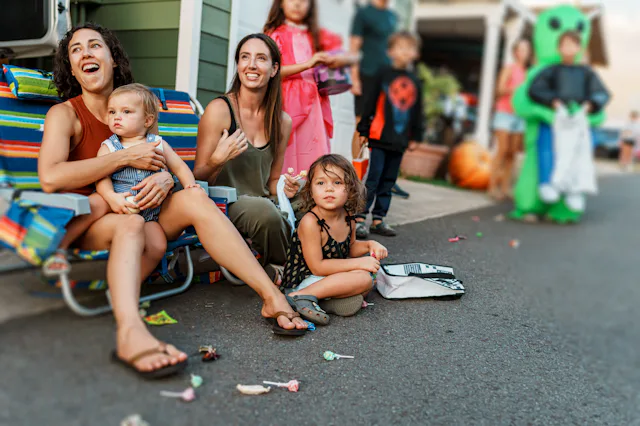 A multiracial group of kids and adults gather along the road in front of their homes in Hawaii as a ...