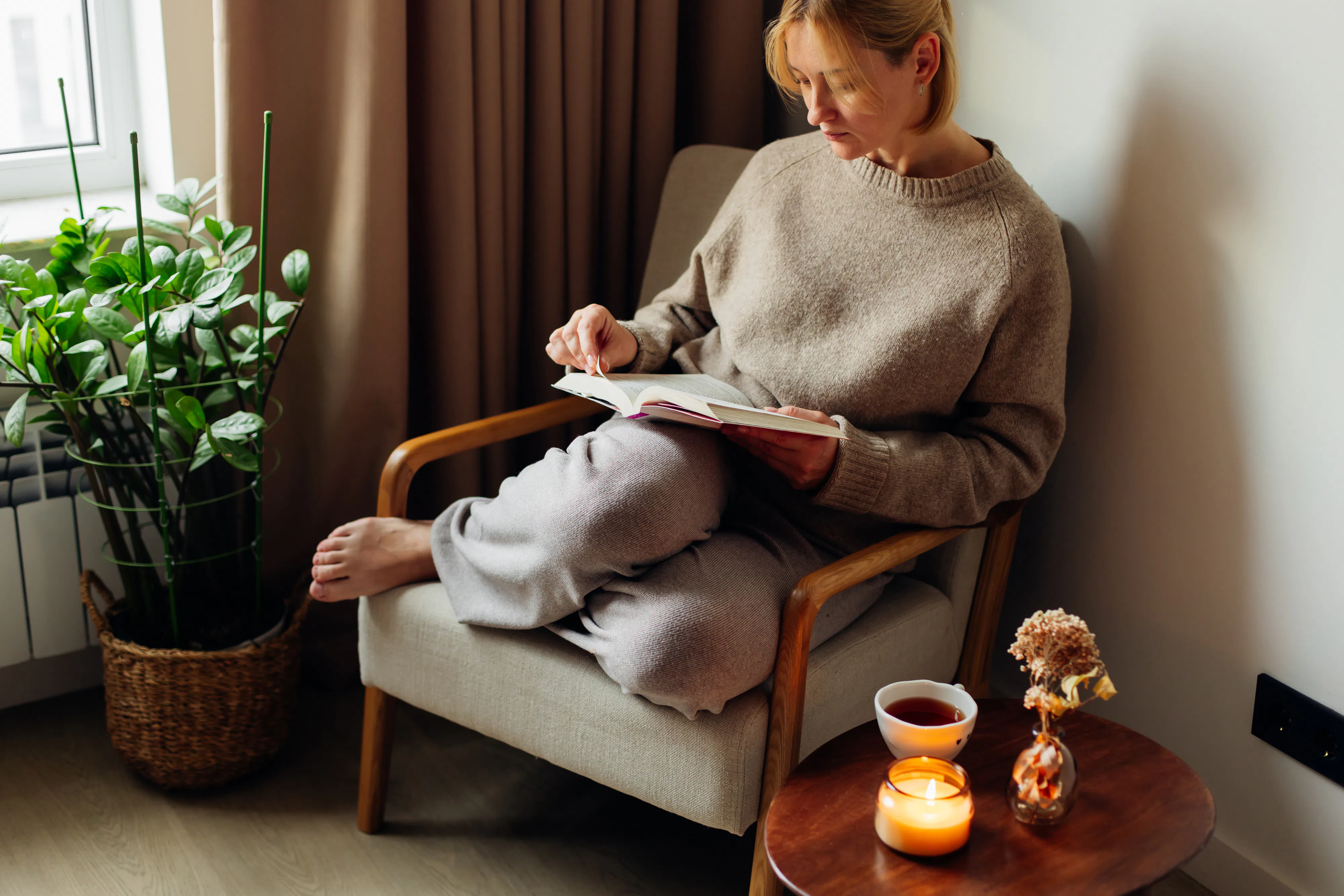 Soft natural light, warm tones, a burning candle and dried flowers create a calm, mindful lifestyle ...