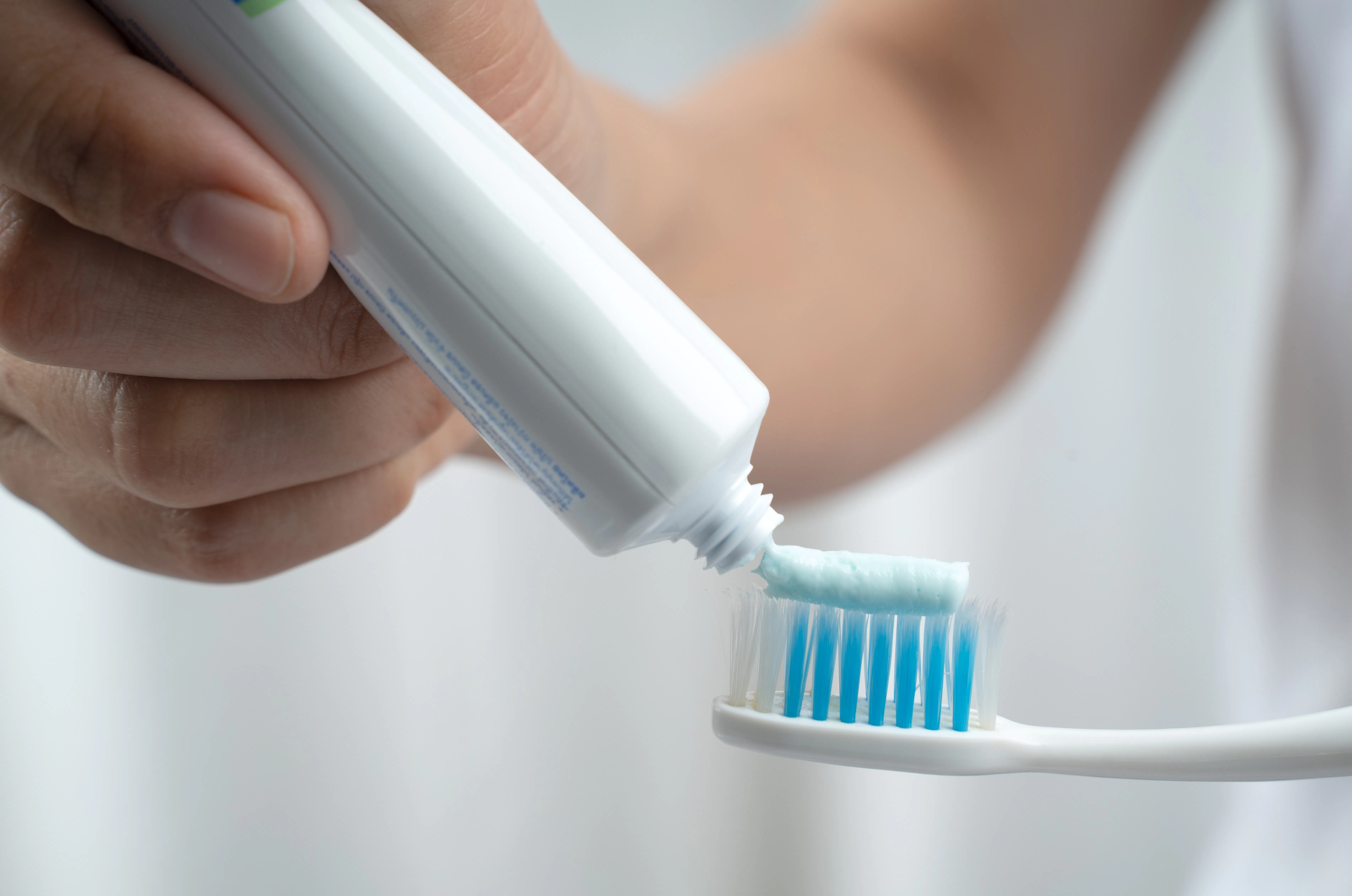 female squeezes toothpaste on the toothbrush