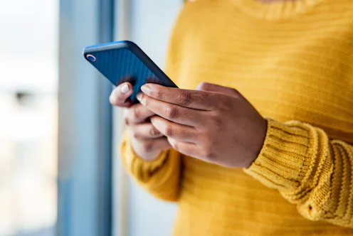 Shot of an unrecognizable woman using a mobile phone indoors