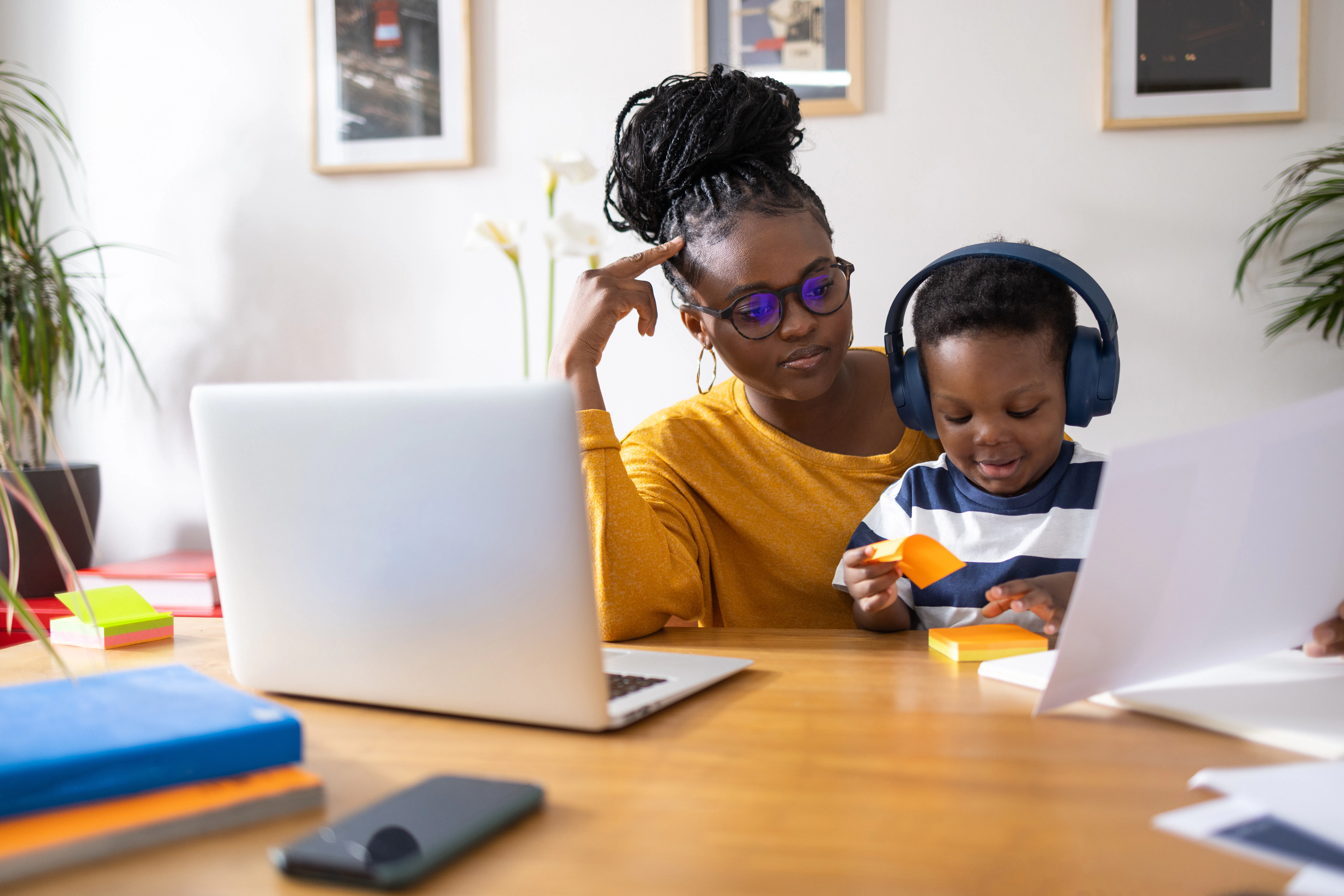 Young mother working from home and taking care of her son at the same time