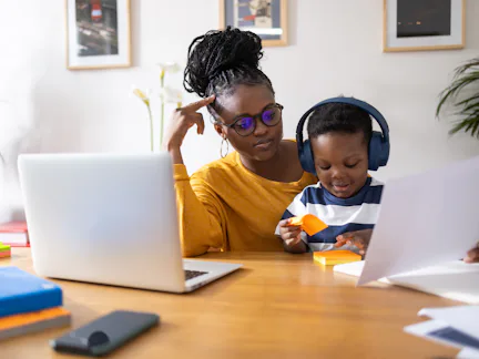 Young mother working from home and taking care of her son at the same time