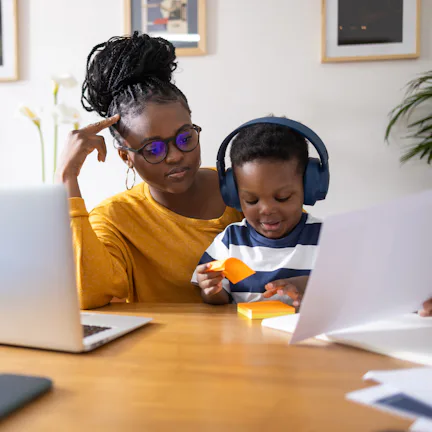 Young mother working from home and taking care of her son at the same time