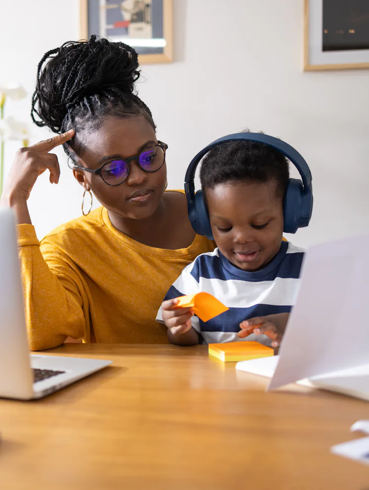 Young mother working from home and taking care of her son at the same time