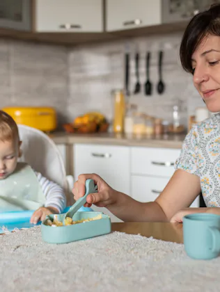 Morning scene of young beautiful mother and her son in the kitchen full of natural light. It's time ...