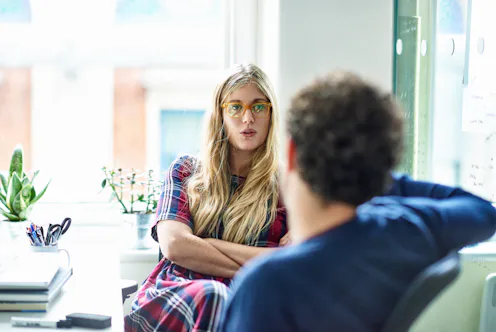 Businesswoman and businessman talking in modern office.