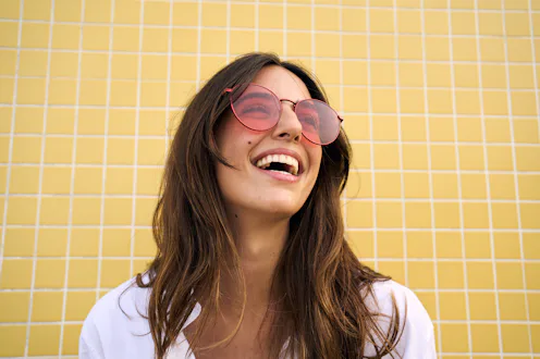 Cheerful and fresh caucasian woman isolated in a yellow background laughing enjoying the summer vibe...