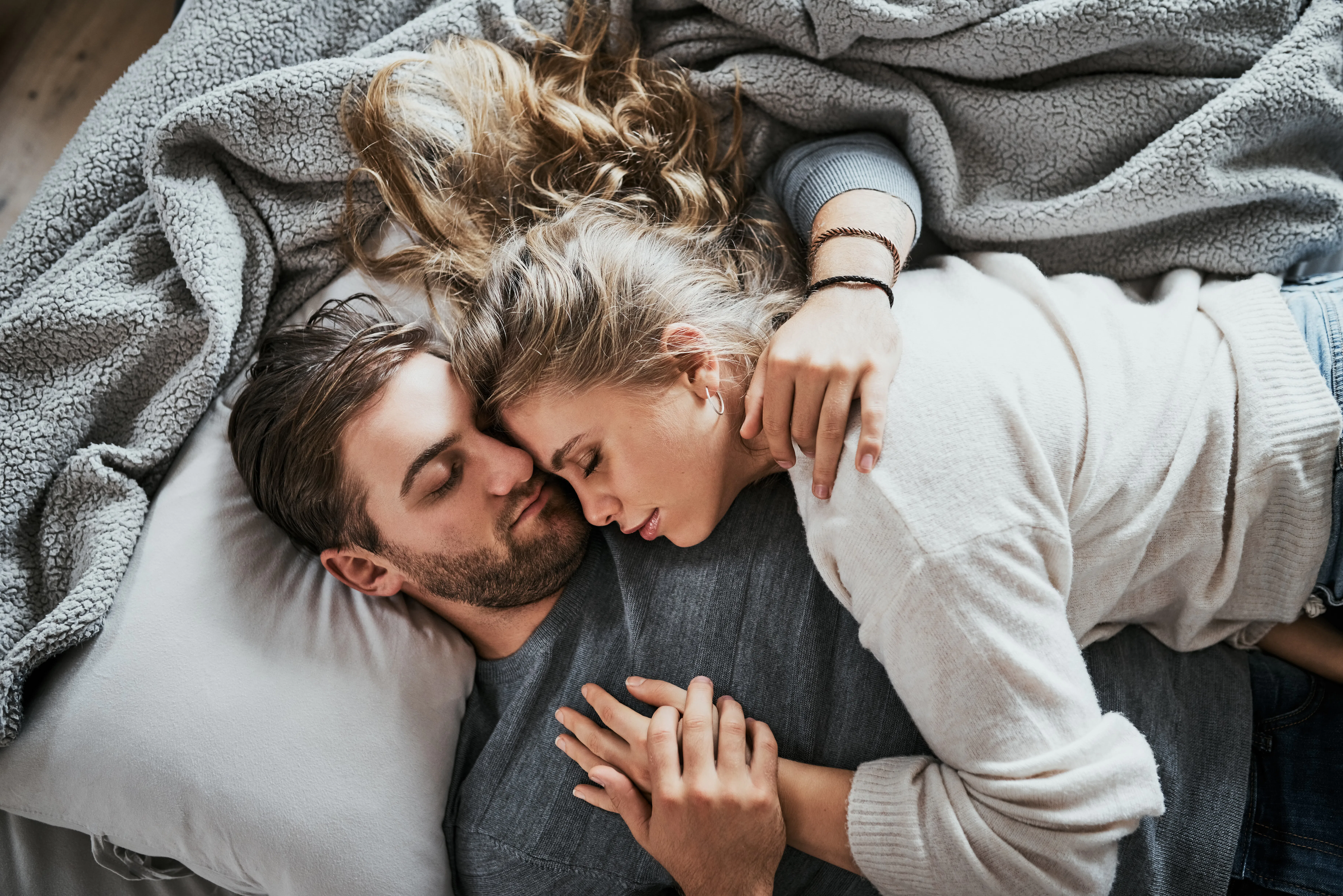 High angle shot of a happy young couple having a nap together in the bedroom at home