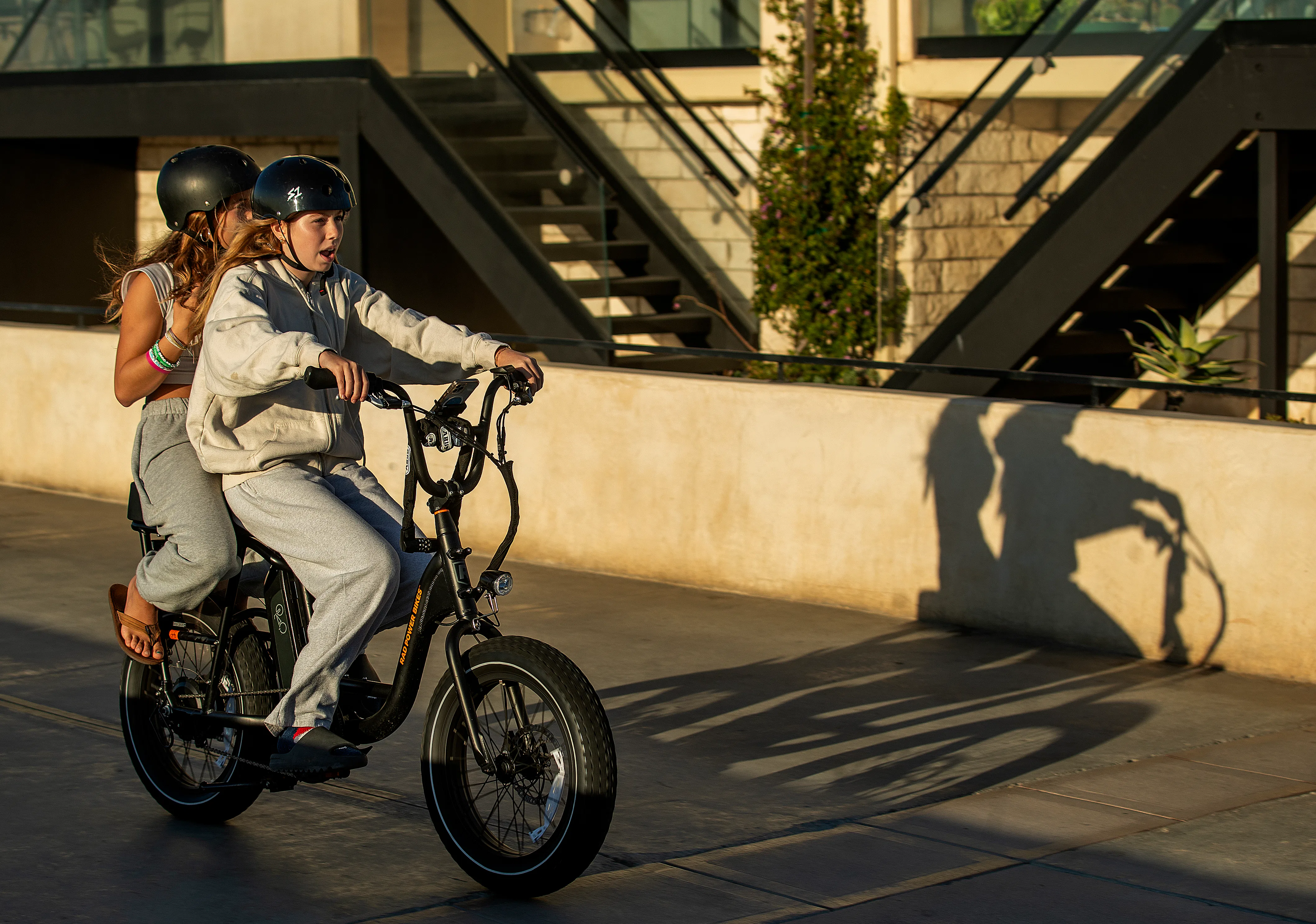 People ride an e-bike on the Strand in Hermosa Beach. 