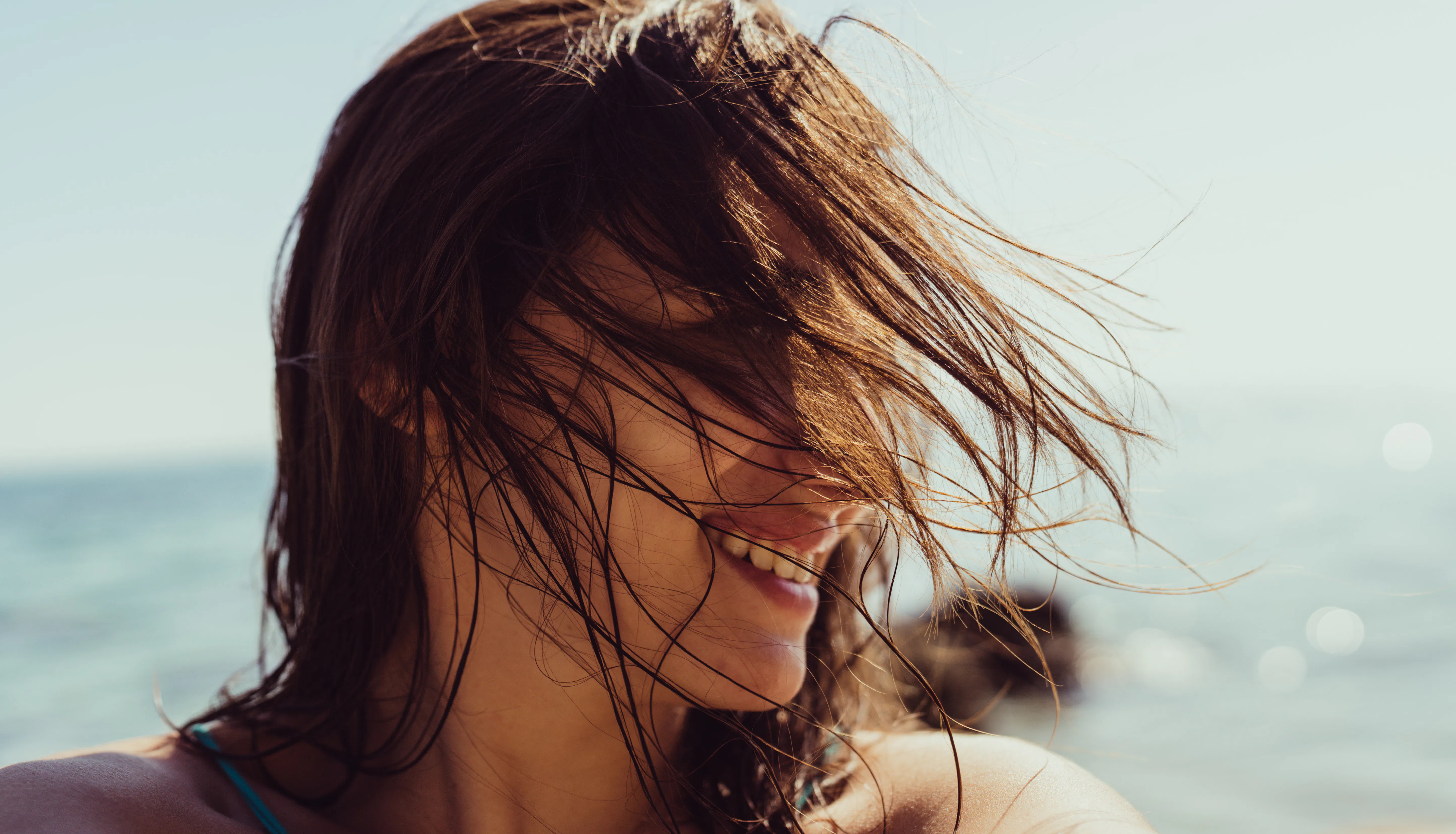 Self-portrait photo of a young woman at the beach.